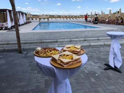 a plate of food on a table next to a pool at STD JOVIC sa bazenom in Lebane
