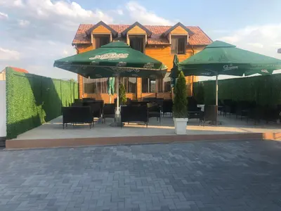 a patio with tables and umbrellas in front of a building at STD JOVIC sa bazenom in Lebane