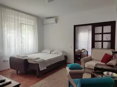 a bedroom with a bed and a couch and a chair at MILA city center-free parking in Vranje