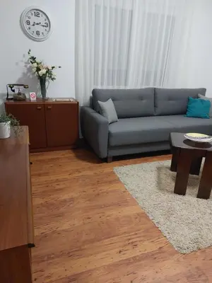 a living room with a blue couch and a table at MILA city center-free parking in Vranje