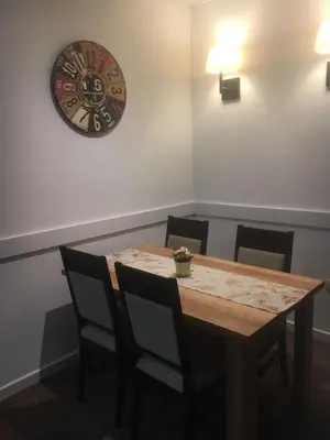 a dining room table with chairs and a clock on the wall at Kopaonik Župa 505 in Kopaonik