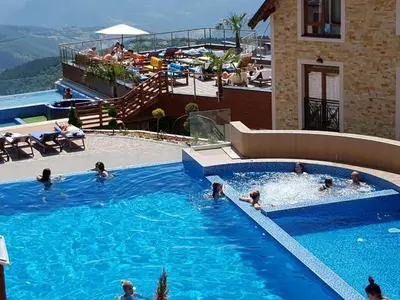 a group of people swimming in a swimming pool at Milmari Resort Lux H-1 in Kopaonik