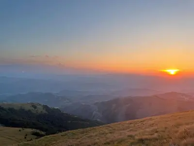 a sunset on the top of a mountain with the sun setting at Milmari Resort Lux H-1 in Kopaonik