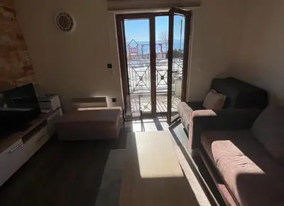 a living room with a couch and a window at Milmari Resort Lux H-1 in Kopaonik