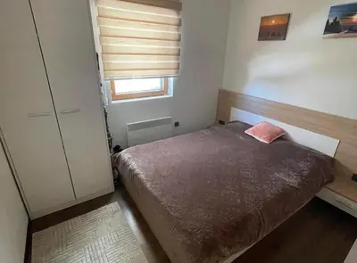 a small bedroom with a bed and a window at Milmari Resort Lux H-1 in Kopaonik