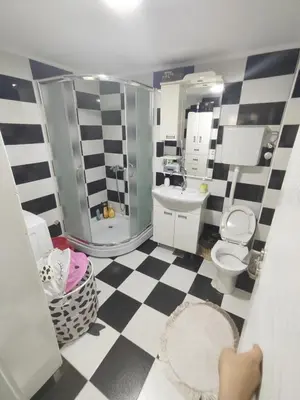 a bathroom with a black and white checkered floor at Bilja's house in Niš