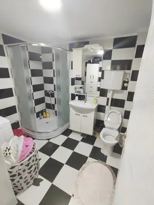 a bathroom with a black and white checkered floor at Bilja's house in Niš