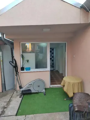 a backyard with a lawn mower and a house at Bilja's house in Niš