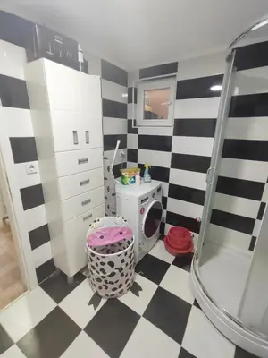 a bathroom with a black and white checkered floor at Bilja's house in Niš