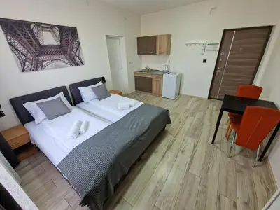 a bedroom with a bed and a table and a kitchen at Vurk INN Paracin in Paraćin