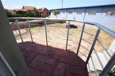 a balcony with a metal railing and a building at Vurk INN Paracin in Paraćin