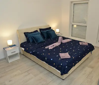 a bedroom with a bed with blue sheets and blue pillows at Stan na dan Raška in Raška