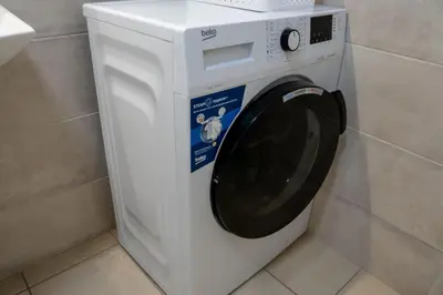 a white washing machine with its door open in a bathroom at Mac Aviator City Center Two Double Bed Apartment in Niš