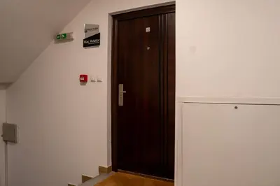 a wooden door in a room with a staircase at Mac Aviator City Center Two Double Bed Apartment in Niš