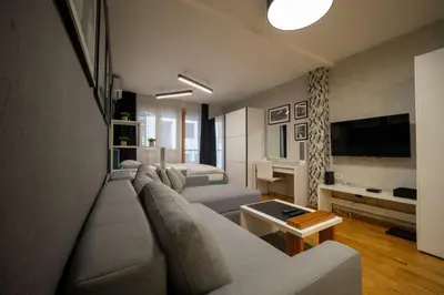 a living room with a couch and a bed at Mac Aviator City Center Two Double Bed Apartment in Niš