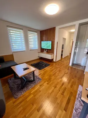 a living room with a table and a flat screen tv at Apartman FiliAki in Vrnjačka Banja
