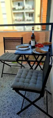 a table with a bottle of wine and a chair at Lala Lux & Parking free in Soko Banja