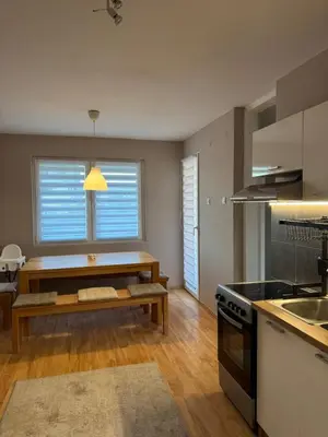a kitchen with a table and a bench in front of a window at Lala Lux & Parking free in Soko Banja