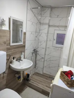 a bathroom with a shower with a sink and a toilet at Holiday House in Zaječar