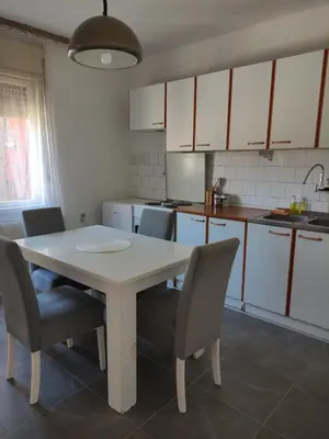 a kitchen with a white table and chairs in it at Holiday House in Zaječar