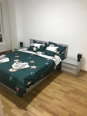 a bedroom with a bed with a green blanket and pillows at Apartman Tara Jagodina, ima free parking u garazi in Jagodina