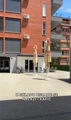 two closed umbrellas in front of a building at Apartman Tara Jagodina, ima free parking u garazi in Jagodina
