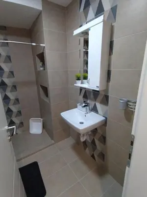a bathroom with a sink and a toilet and a mirror at Apartman Tara Jagodina, ima free parking u garazi in Jagodina