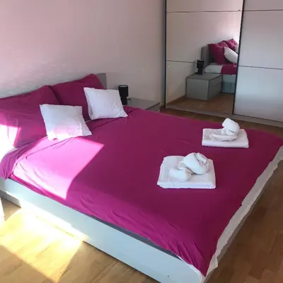 a large pink bed with towels on top of it at Apartman Tara Jagodina, ima free parking u garazi in Jagodina