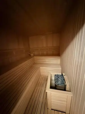 a small sauna with a wooden floor and a box at Apartman Skyline Kopaonik in Kopaonik