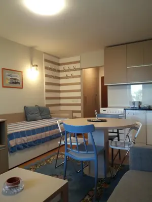 a kitchen and living room with a table and a bed at VILA BJANKA 205 in Kopaonik
