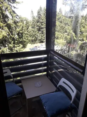 a balcony with two chairs and a table and a window at VILA BJANKA 205 in Kopaonik