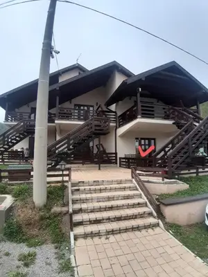 a building with stairs in front of it with a pole at Apartman Popadić-Goč in Biserske Kuće