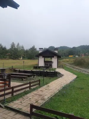 a park with a building in the middle of a field at Apartman Popadić-Goč in Biserske Kuće