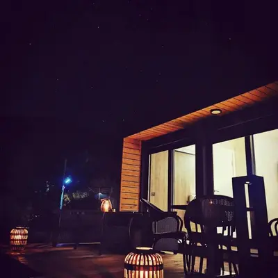 a screened in porch at night with a table and chairs at EHINACEA in Rtanj