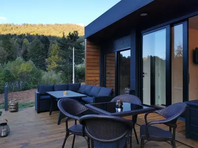 a patio with a couch and tables and chairs at EHINACEA in Rtanj