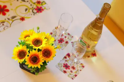 a table with a bottle of wine and a vase of sunflowers at Magic Dream Lux apartman in Vrnjačka Banja