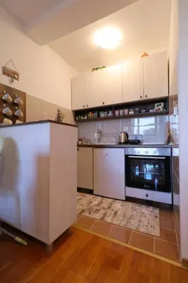 a kitchen with white cabinets and a stove top oven at Magic Dream Lux apartman in Vrnjačka Banja