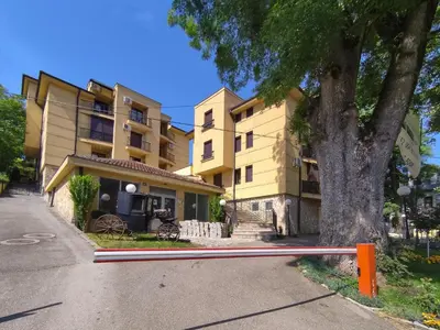 a building with a tree in front of it at Magic Dream Lux apartman in Vrnjačka Banja