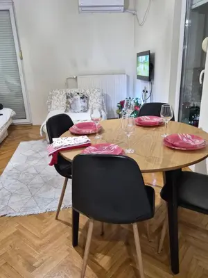 a dining room table with chairs and wine glasses at Apartman I&V in Vrnjačka Banja