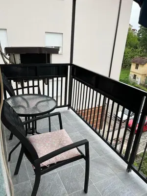 a balcony with a table and a chair on a balcony at Apartman I&V in Vrnjačka Banja