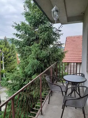 a table and chairs on a balcony with a tree at Beli Ocnjak in Soko Banja