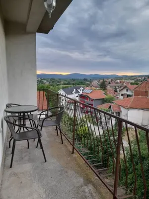 a balcony with two chairs and a table with a view at Beli Ocnjak in Soko Banja