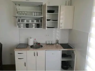 a small kitchen with a sink and white cabinets at M & M in Vrnjci