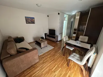a living room with a couch and a table at SAD Apartman in Niš