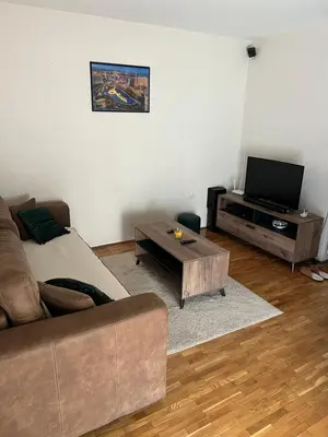 a living room with a couch and a flat screen tv at SAD Apartman in Niš