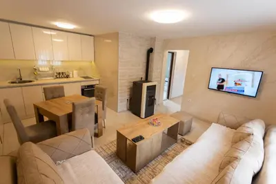 a living room with a couch and a table at Vila Oaza mira Draganići in Raška