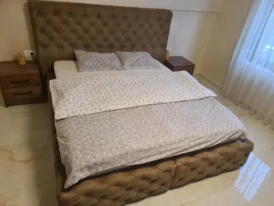a bedroom with a bed with a brown tufted headboard at Vila Oaza mira Draganići in Raška