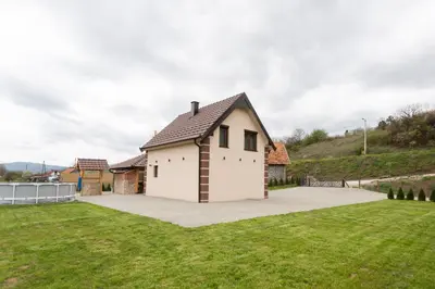 a white house with a large yard at Vila Oaza mira Draganići in Raška