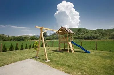 a playground with a slide and a swing at Vila Oaza mira Draganići in Raška