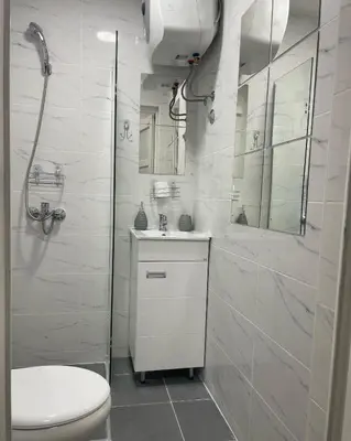 a white bathroom with a toilet and a shower at Apartman 5 Vrnjačka Banja in Vrnjačka Banja